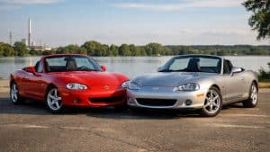 Mazda MX-5 NB rouge et Mazda MX-5 NBFL grise côte à côte, photographiées de face en extérieur.