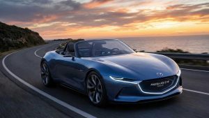 Mazda MX-5 NE conceptuelle, bleue sur une route de montagne sous un couché de soleil