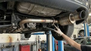 Inspection de la ligne d’échappement d’une Mazda MX-5 sur pont élévateur lors d’un contrôle technique.