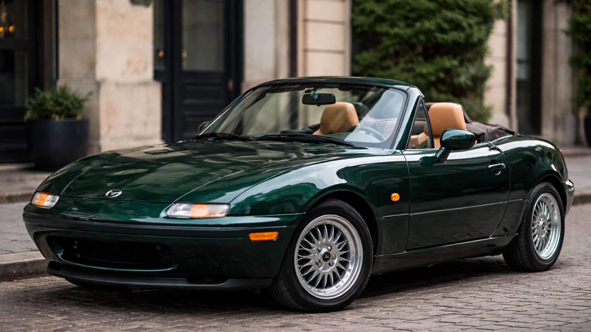 British Racing Green NA Miata with the top down and tan interior