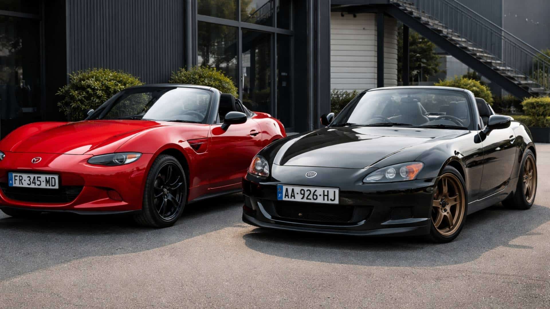 Mazda MX-5 ND rouge stationnée aux côtés d’une Honda S2000 noire, deux roadsters japonais emblématiques comparés côte à côte.
