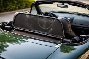 Windschott (déflecteur de vent) installé derrière les sièges d’une Mazda MX-5 NB verte, capote ouverte, en lumière naturelle