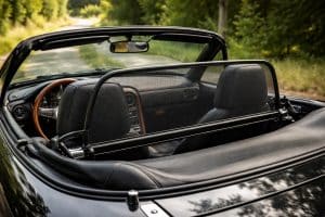 Balise alt (1 phrase) : windschott_mx5_na_installe_derriere_les_sieges_sur_mazda_mx_5_na_decouverte_pare_vent_en_filet_noir