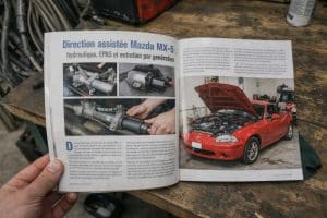 Direction assistée Mazda MX-5 NBFL rouge en atelier, magazine ouvert montrant la crémaillère hydraulique, un système EPAS et le compartiment moteur de la Mazda MX-5