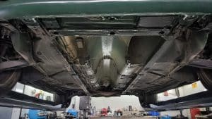 Vue d'ensemble du dessous sain d'une Mazda MX-5 verte sur pont, tunnel de transmission et longerons