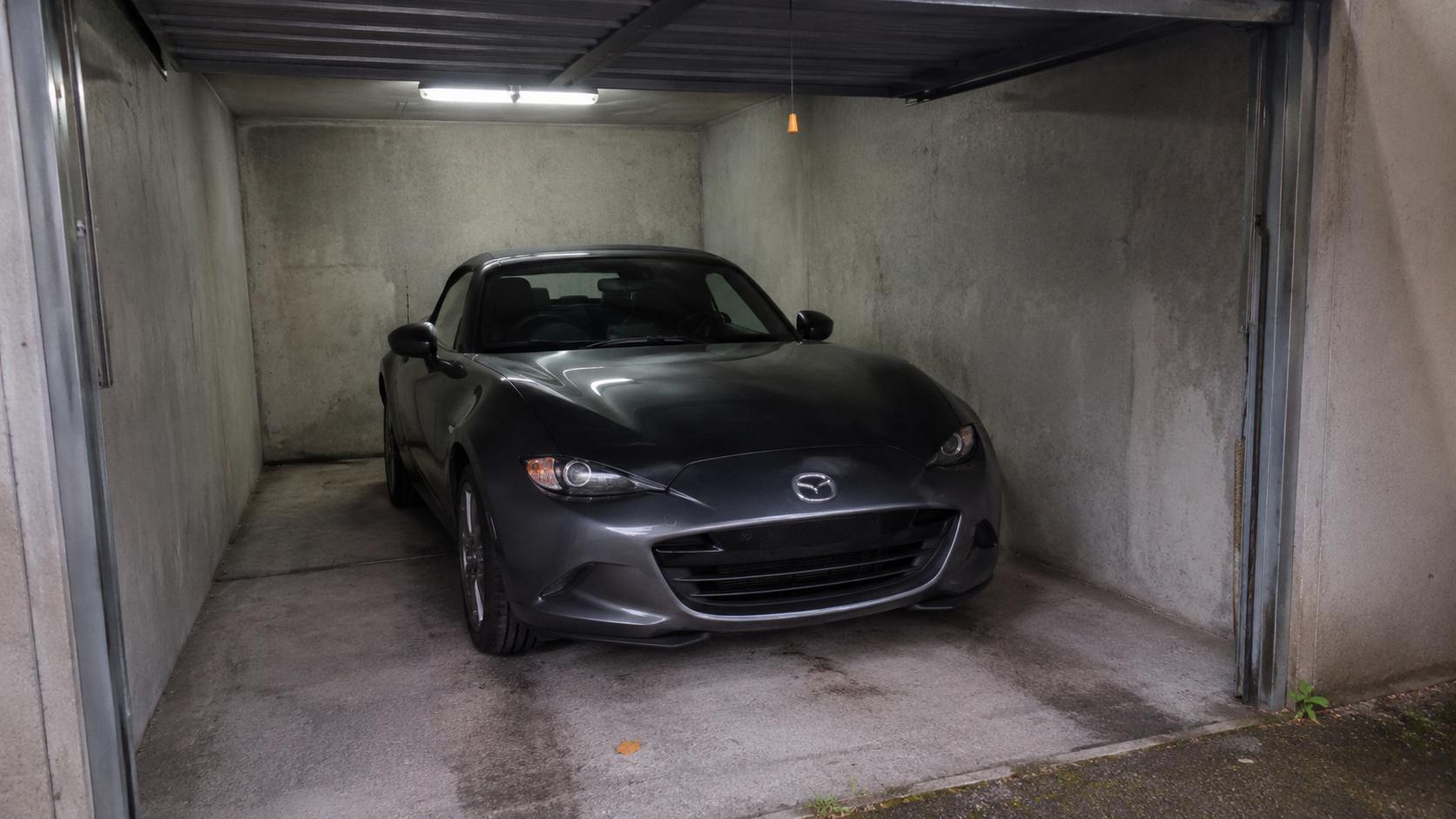 Mazda MX-5 ND gris anthracite stationnée dans un box fermé en béton