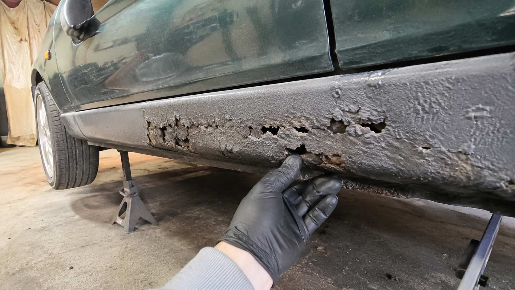 Corrosion perforante sur le bas de caisse d'une Mazda MX-5 NB verte inspectee en garage